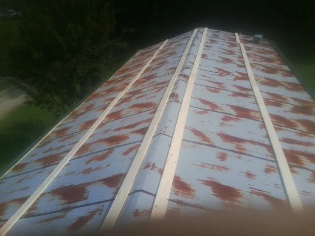 Rusted metal roof panels with new wood purlins before replacement — Storm Damage Roof Repair in Connersville by Roofing Brothers